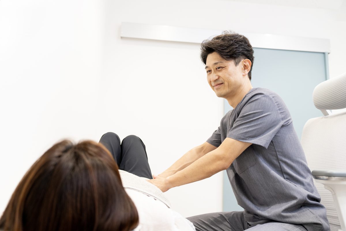 腹部の触診を行う院長
